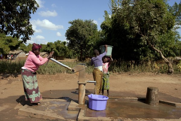 Des femmes et des enfants puisant de l’eau dans un forage à Mzingo, un village du Malawi. <br> Photo : ©FAO/Amos Gumulira