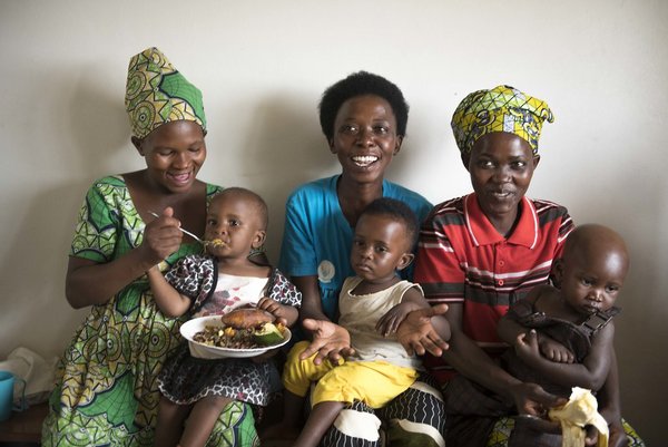 Mothers in Rwanda feed their children with a bio-fortified sweet potato puree.